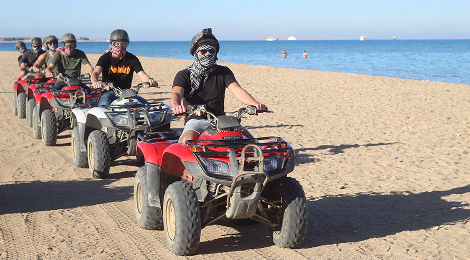 Guests riding quad bikes on a desert safari